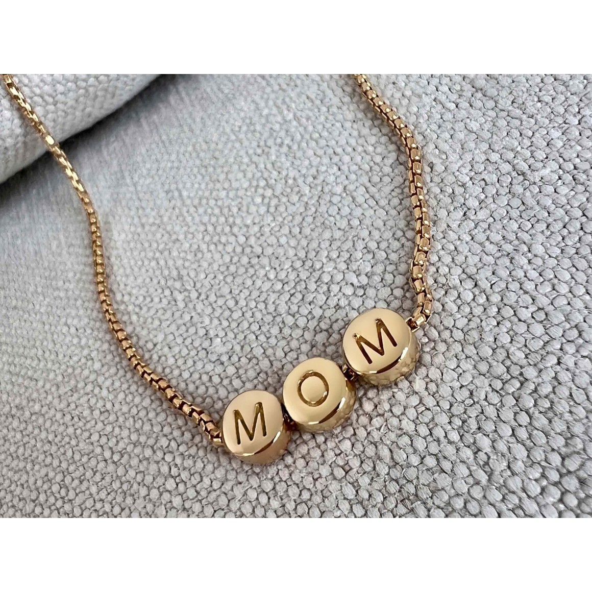 Teilansicht goldene Letter Halskette von strawberry & cream mit drei Perlen auf einer Venezianerkette