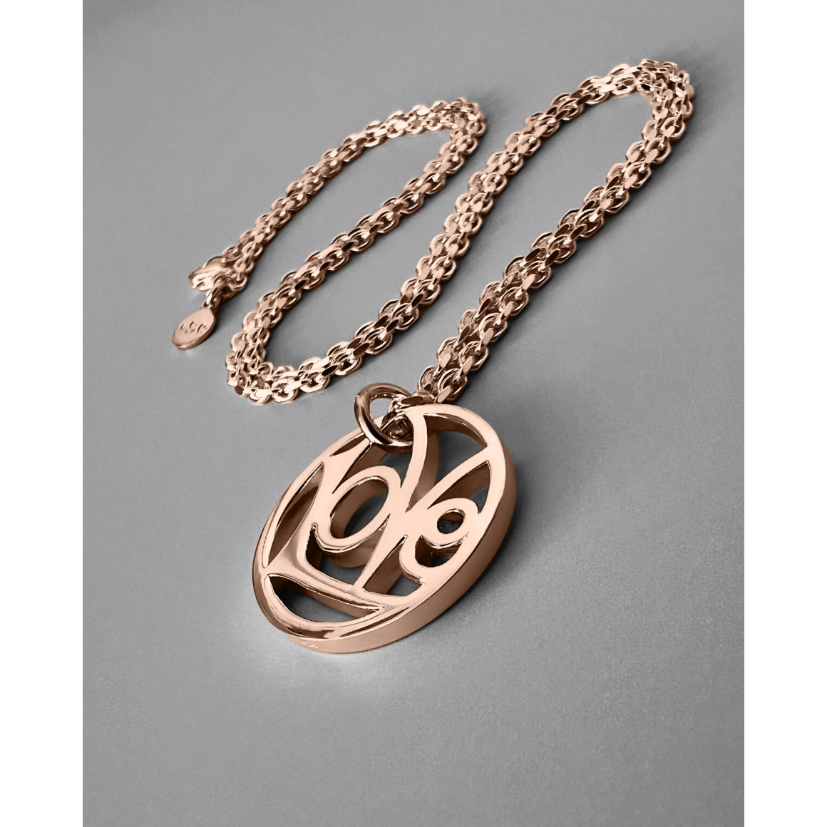 Liegend fotografierte LoVe Halkette von strawberry & cream in rosegold mit diamantierter Ankerkette